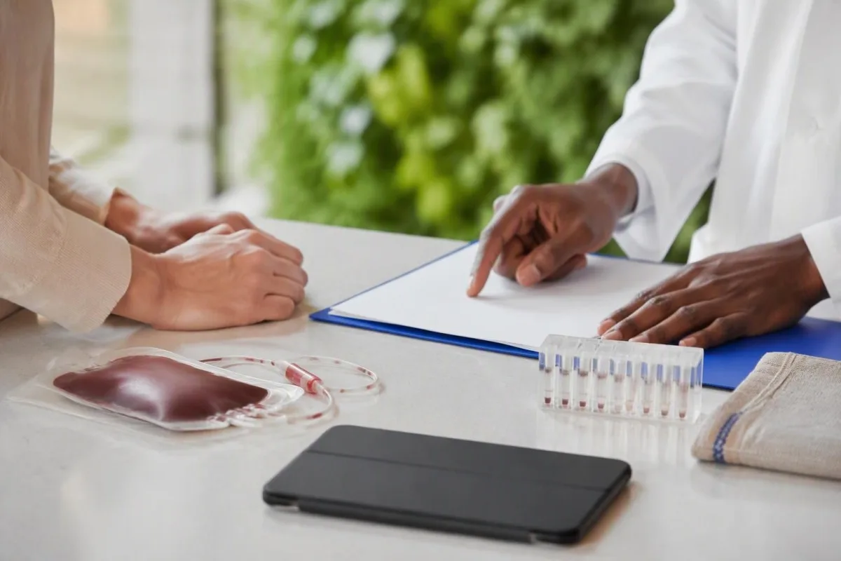 Crossmatch test discussion showing hands reviewing unmarked transfusion records beside a donor-unit segment