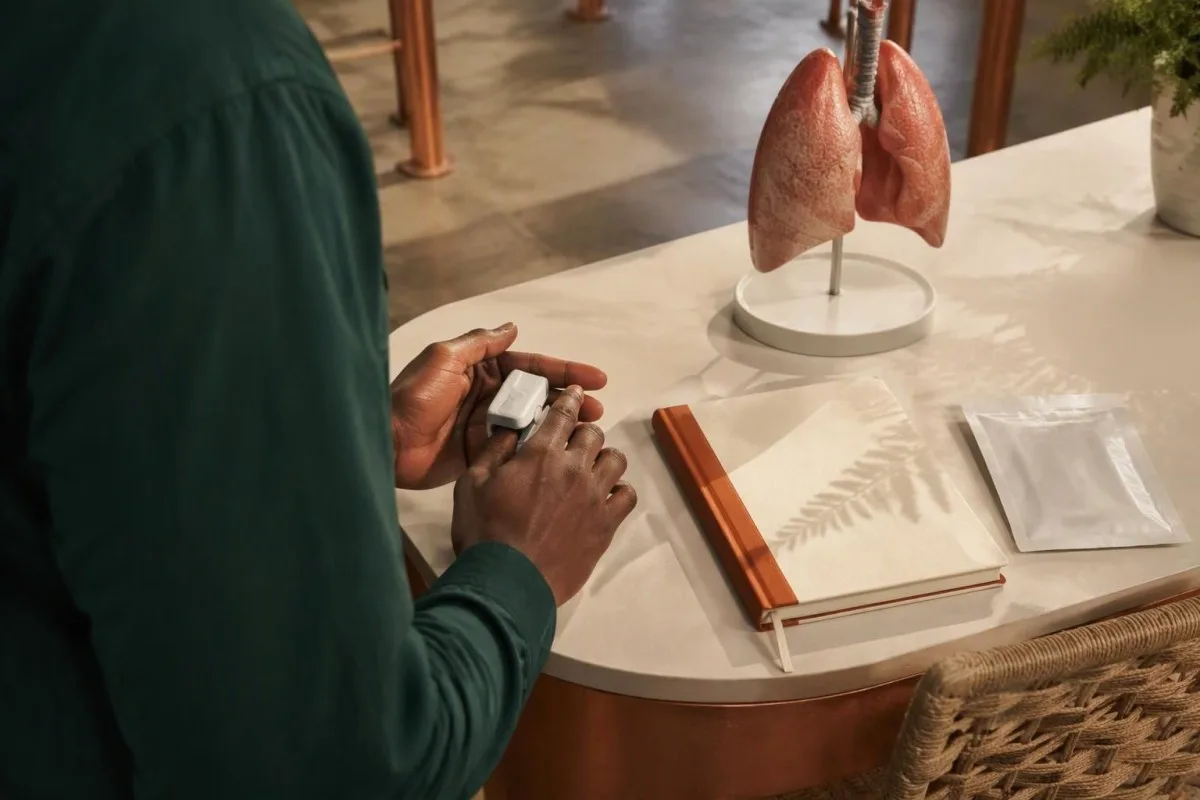 Hands-only recovery assessment using a pulse oximeter beside a lung diagram and prior urine specimen